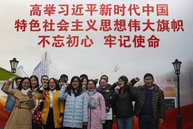 the picture is showing that a lot of peoplle taking oath in front of a banner that promoting Xi's though