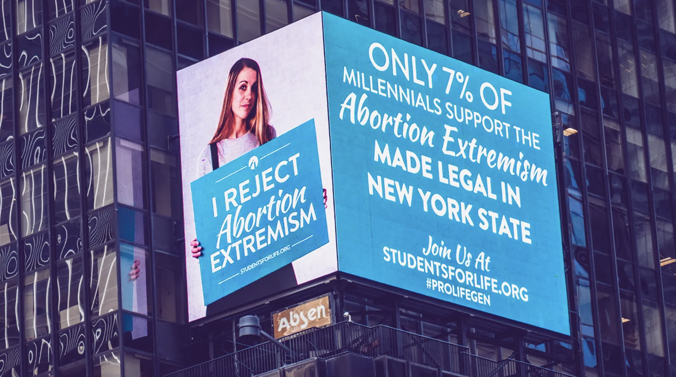Woman holding sign saying "I reject abortion extremism" to the right of her a message reads "Only 7% of millennials support abortion extremism made legal in New York State. Join us at Stuentsforlife.org #prolifegen"