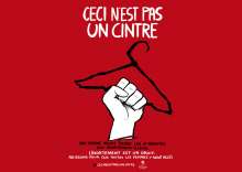 Une main tient un cintre sur un fond rouge sang 